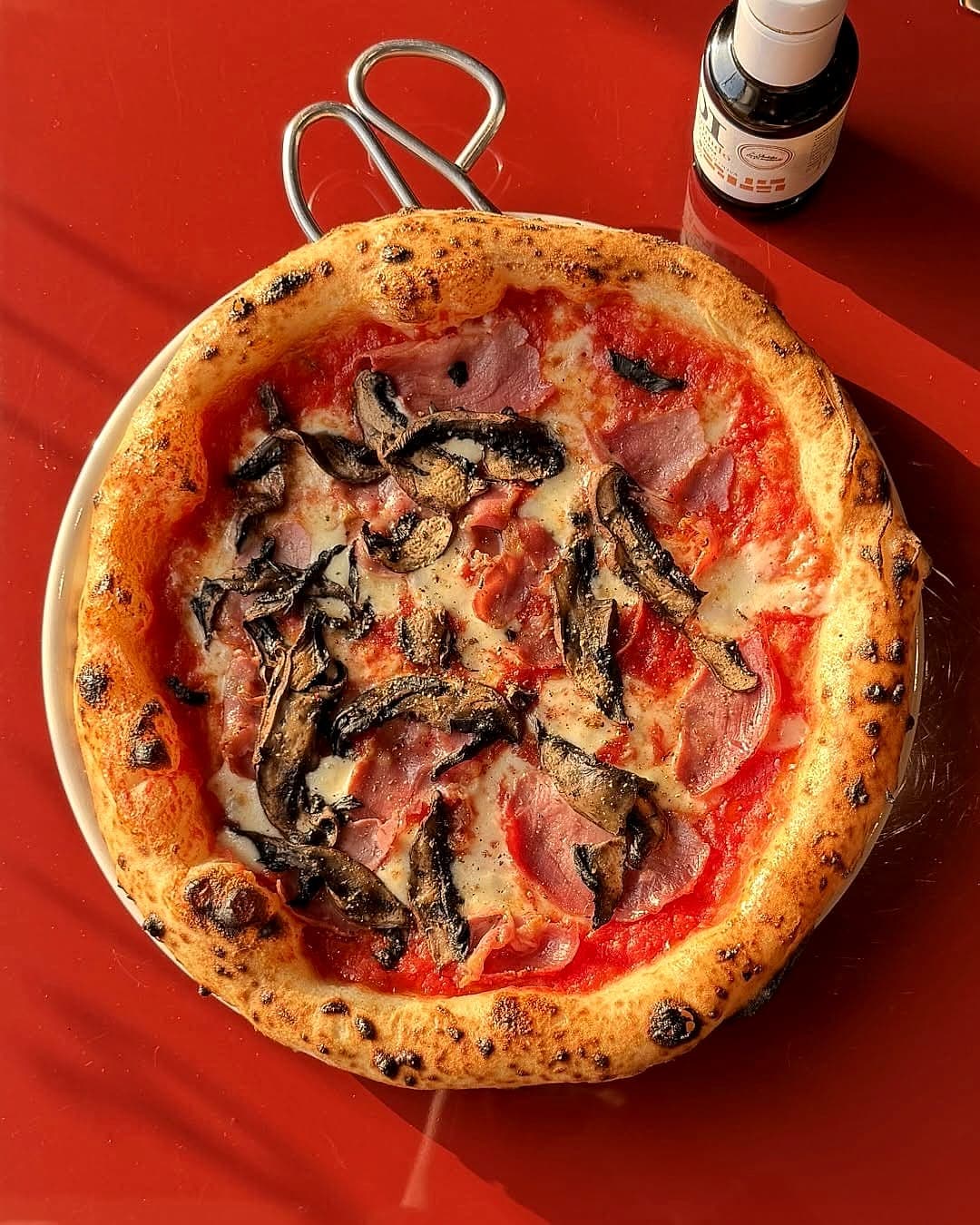 Pizza from above on a red table in low sun